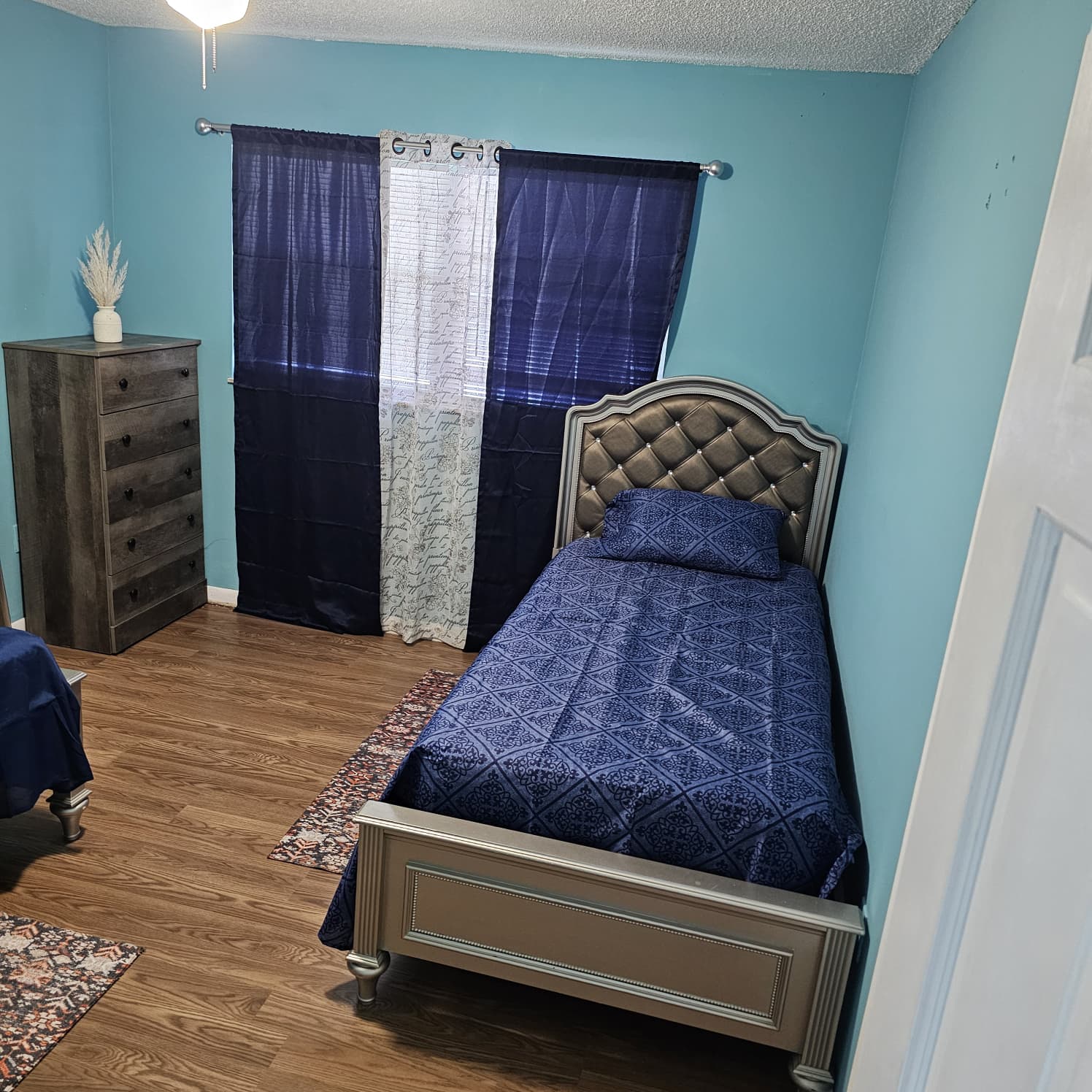 Private resident bedroom with dresser and window